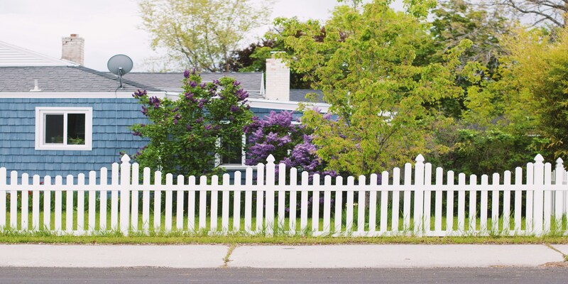 White picket fence around a landscaped home